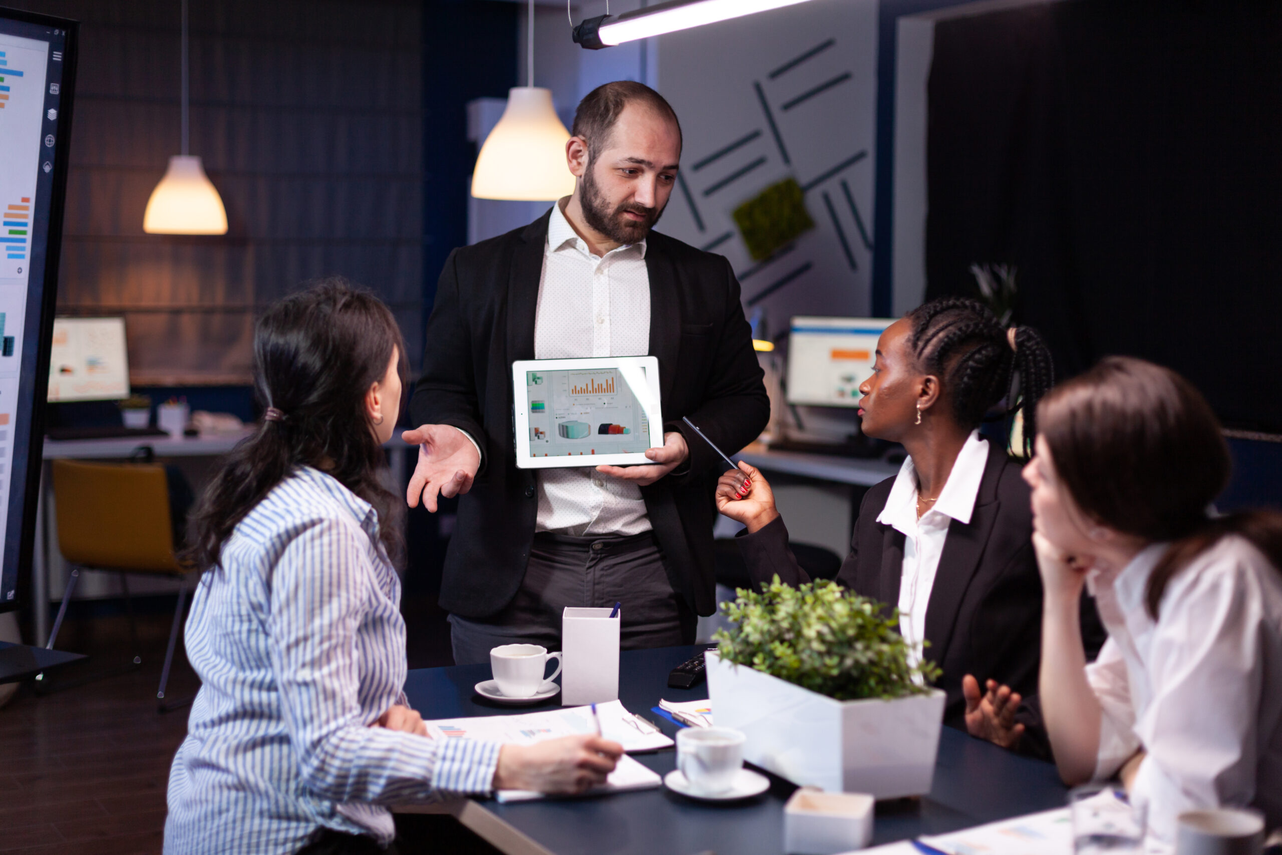 overworked businessman showing financial graphs presentation using tablet